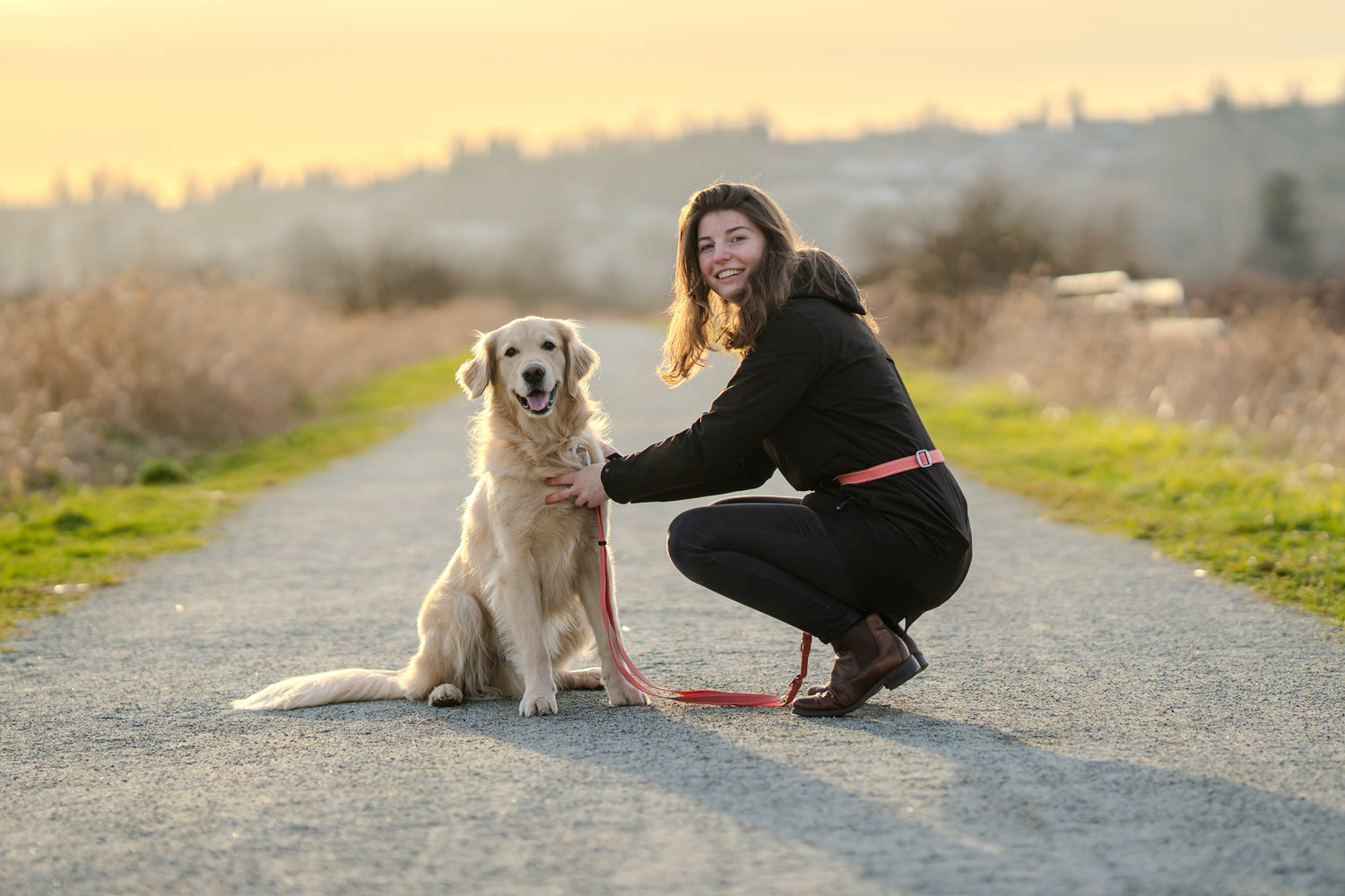 DogGo's Founder, Julie and her golden retriever Gus at sunset.